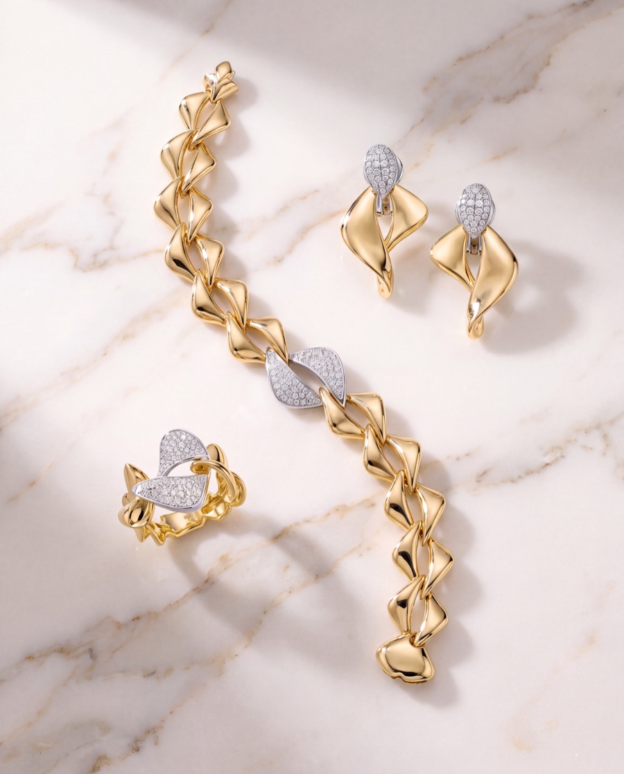 Gold and diamond bracelet and earrings on white marble